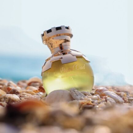 Luxury Pearl Oud Eau de Parfum bottle with elegant golden detailing displayed on seashells with premium packaging beside it.
